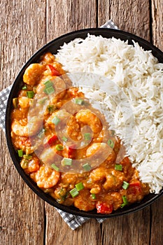 Shrimp EtouffeeÂ  Juicy dish smothered in rich and flavorful roux sauce served with rice closeup in a plate. Vertical top view